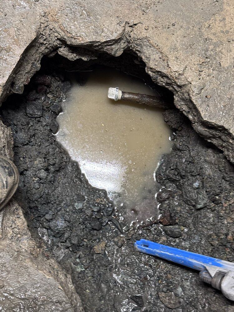 Plumber repairing a corroded pipe leak with a pipe repair clamp